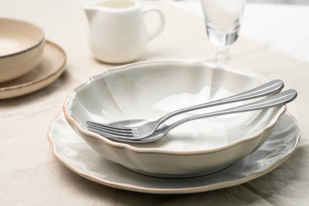 istock An empty plate with a spoon and a fork on a table with a tablecloth. Studio shot from a low angle. 1445546692