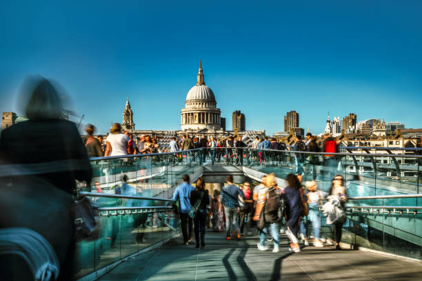 People crossing Millenium Bridge in London with St Paul's Cathedral in the background stock photo