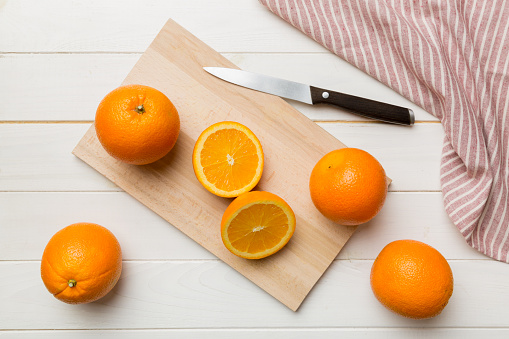 Fresh ripe oranges on cutting board on table. Top view Flat lay.