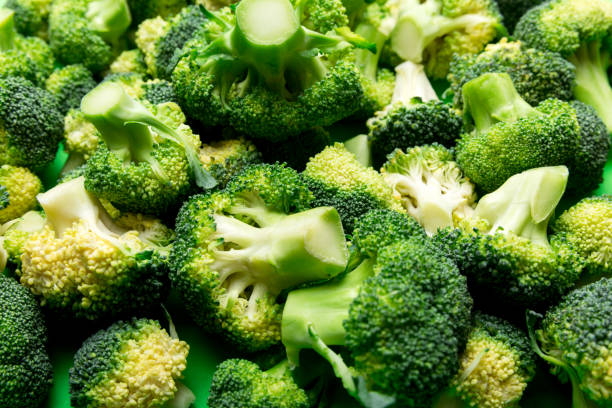 istock green fresh broccoli background close up on colored table. Vegetables for diet and healthy eating. Organic food 1445551102