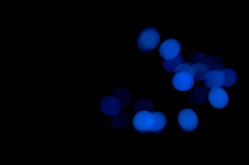 Blue blurry bokeh lights on black background