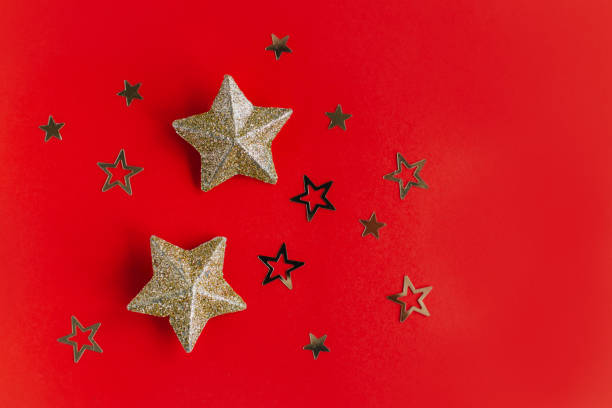 istock Golden sparkling stars on a red background. Flat lay. 1445552574