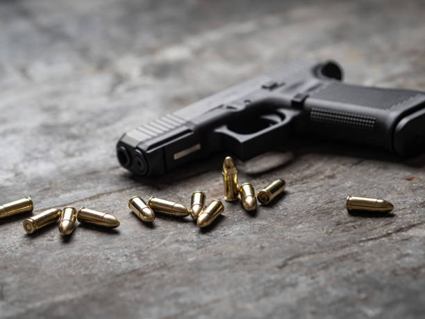 istock Hand gun with ammunition on dark background. 9 mm pistol. 1445552928