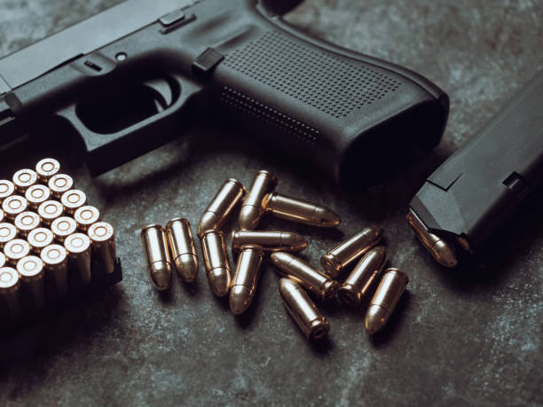 istock Hand gun with ammunition on dark background. 1445552933