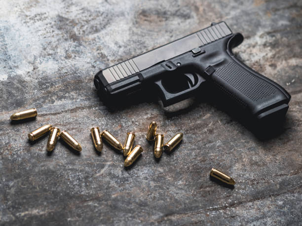 istock Hand gun with ammunition on dark background. 9 mm pistol. 1445552970