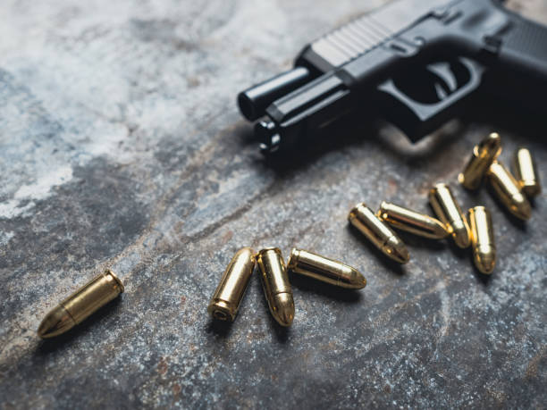 istock Hand gun with ammunition on dark background. 9 mm pistol. 1445552987