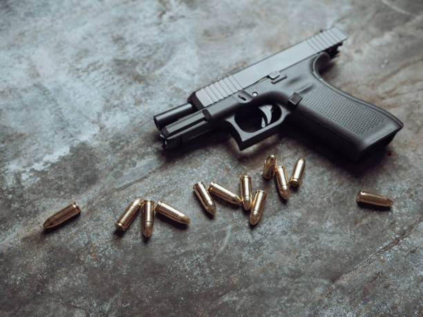 istock Hand gun with ammunition on dark background. 9 mm pistol. 1445553044