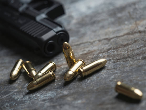 istock Hand gun with ammunition on dark background. 9 mm pistol. 1445553552