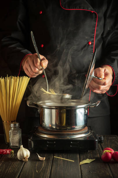 istock Cooking delicious soup for lunch. Working environment in the kitchen. Chef cooking spaghetti in a pot 1445554589