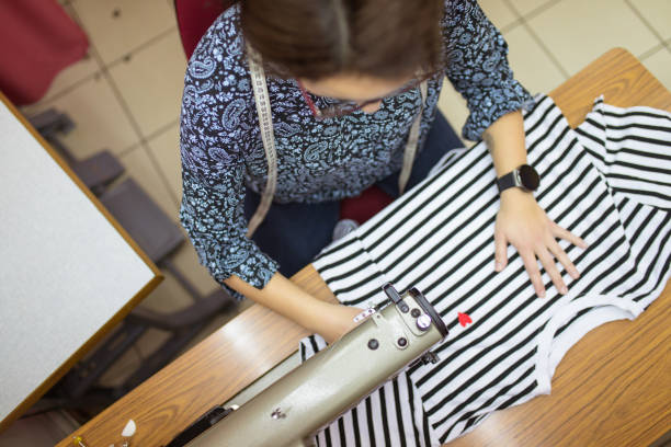 Woman tailor at work on sewing machine.