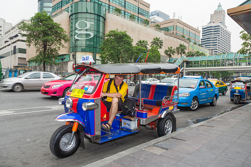 Bangkok, Thailand - May 11, 2009: male tourist in a three weel taxi called bemo poses for a souvenir photo.in Bangkok.