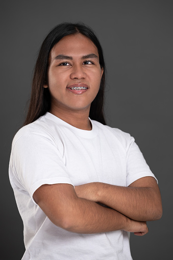 Smiling with teeth native american man with crossed arms isolated on studio background