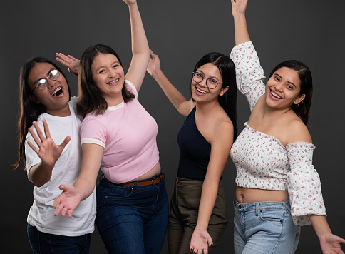 Portrait of group happy young hispanic people on studio background