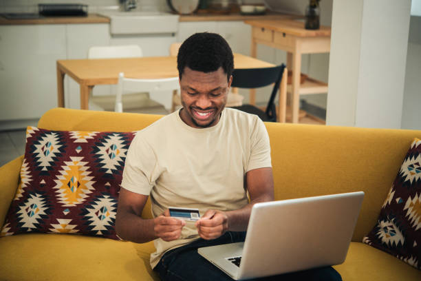 istock Young African American making an online payment from home 1445564566