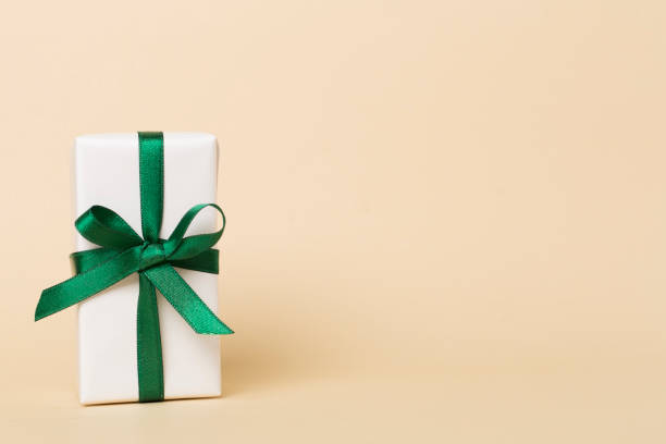 istock Gift box with green ribbon bow on color background 1445564794