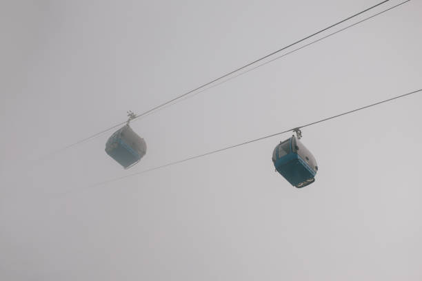 Funicular moves in the sky high in the foggy mountains.