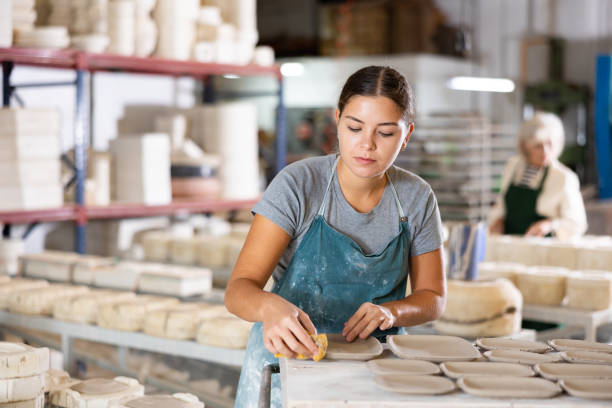 istock Ceramist polishing new clay plates 1445566307