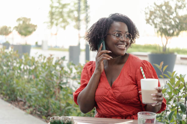 istock Afro woman walking and talking on mobile phone 1445578206