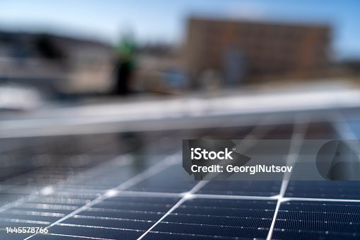 istock A small crew installs solar panels on the roof of an industrial building. 1445578766