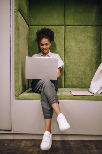 Young woman working on laptop sitting indoors
