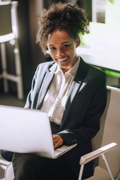 istock Woman working on laptop smiling at camera 1445580120