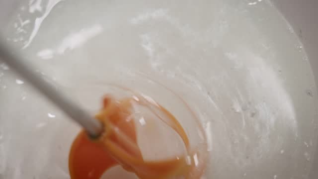 The process of preparing a multi-component epoxy resin. A professional kneads the resin with a colored tint