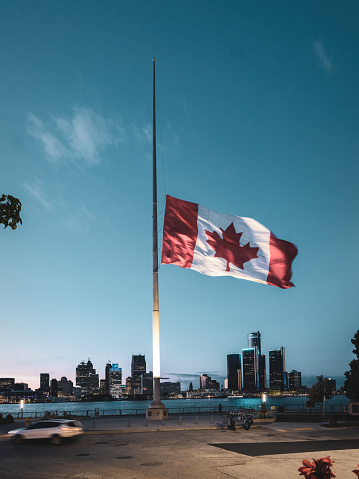 The Canadian flag is at half-mast flying in the foreground of Detroit, Michigan, Windsor's neighbour across the river.