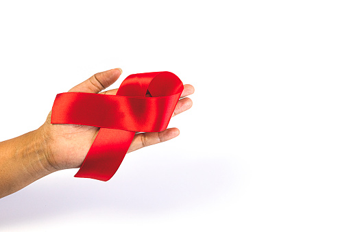 Woman holding a red ribbon December 1 of every year People around the world hold World AIDS Day to remember those who have died from acquired immunodeficiency syndrome (AIDS).