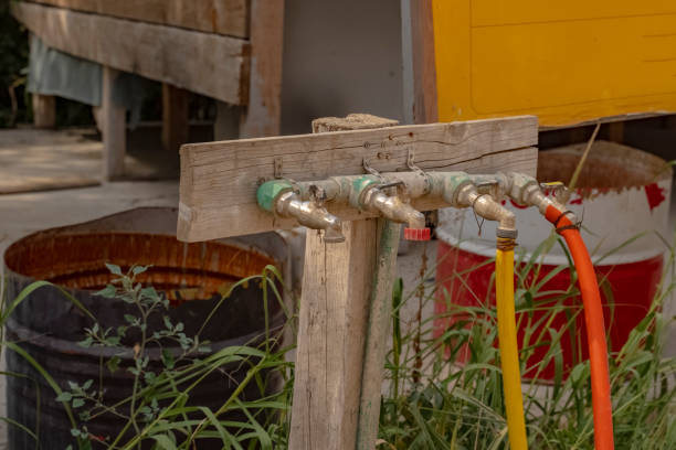 zbliżenie kilku zewnętrznych kranów podłączonych do węży wodnych na placu budowy. dźwigi z wodą przemysłową dla budowniczych. - leaking faucet water scarcity zdjęcia i obrazy z banku zdjęć