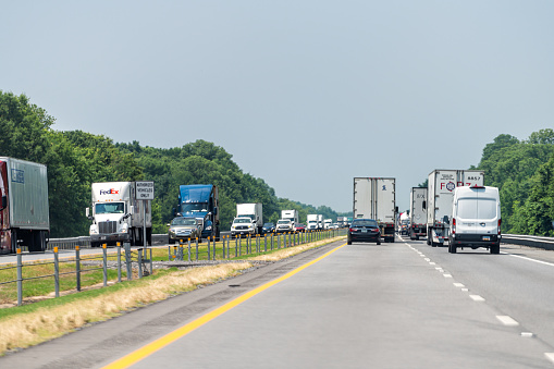 Brinkley, USA - June 4, 2019: Highway i40 interstate road in Arkansas with heavy traffic of many cars trucks driving point of view pov in summer
