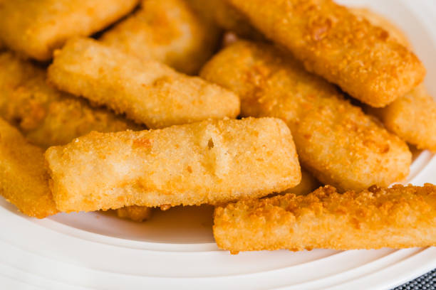 istock Fish sticks in a crunchy golden breading close-up on white plate on the kitchen table 1445608427