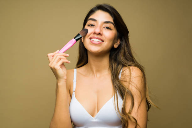 istock Latin woman using a makeup brush to use beauty products 1445619246