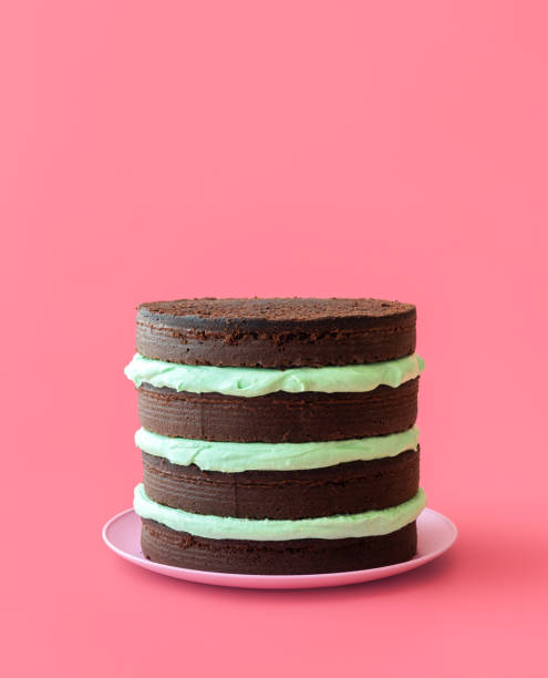 Chocolate mint cake isolated on a pink background Homemade cake with peppermint cheese cream and chocolate base. Layered cake with mint flavor cream minimalist on a pink table birthday cake green stock pictures, royalty-free photos & images