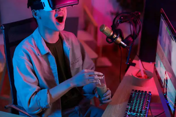 Emotional lets player drinking iced coffee when recoding himself playing video game in virtual reality headset