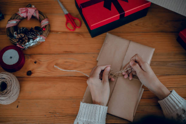 istock Woman wrapping presents and tying a bow at her gift box 1445628756