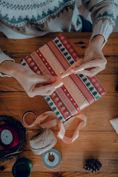 istock Woman wrapping presents and tying a bow at her gift box 1445628806