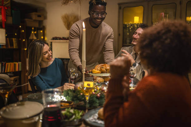 istock Happy man serving roast turkey during Christmas dinner 1445629370