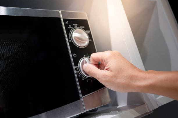 istock Male hand turning temperature knob of microwave 1445630132
