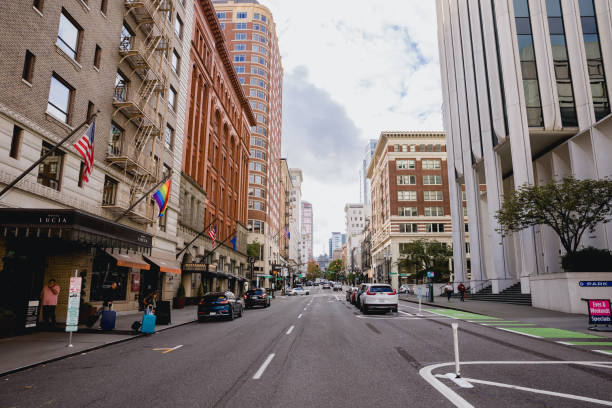 The streets of Downtown Portland Oregon on a Sunday afternoon in the fall. Shot on SW Broadway street. A few people can be seen walking along the sidewalks.
