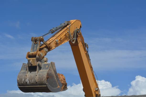 istock Excavator bucket backhoe with soil against the blue sky 1445641147