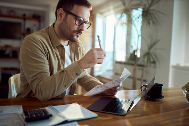 istock Young man working on his financial bills at home. 1445644662