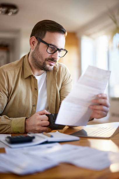 istock Young man analyzing his financial bills at home. 1445645533