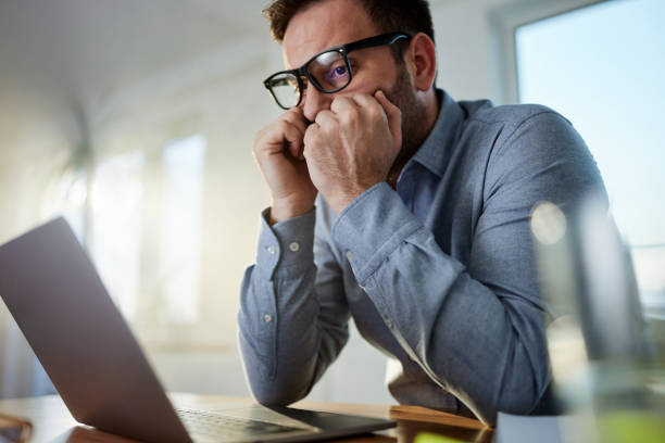 istock Worried businessman working on a computer at home office. 1445646131