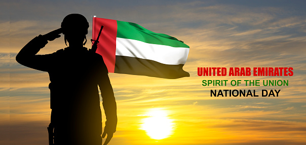 Silhouette of a saluting soldier on background of the sunrise and UAE flag. Concept for Commemoration Day, Martyrs Day, National Day