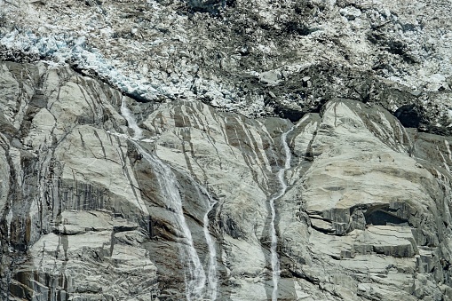 Climate change. View of the Brenva glacier melting creating large waterfalls. Courmayeur, Italy