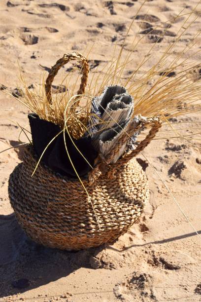 istock Vertical shot of a basket with small rug on a sandy beach 1445649594