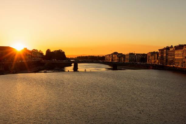 istock Golden sunset with sunbeams over river in Florence 1445650414
