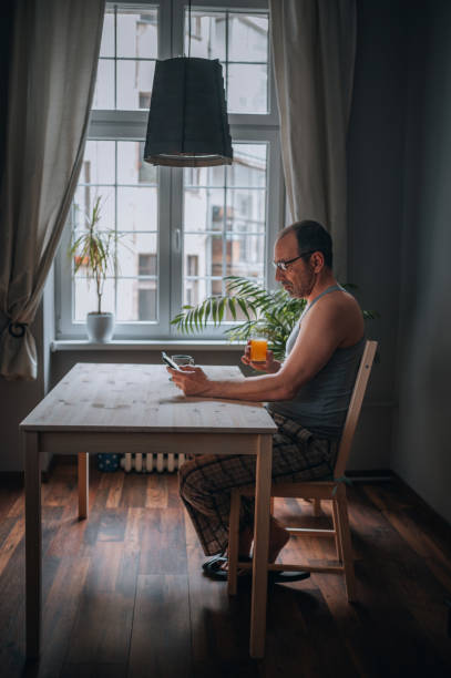 istock A man sitting in the kitchen and using smartphone 1445652234