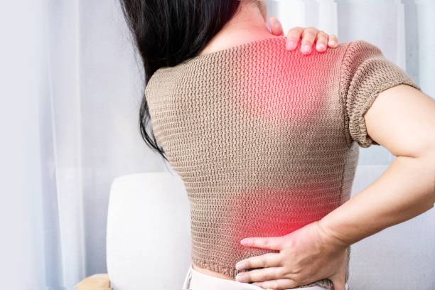 woman suffering from shoulder pain or upper back spreading to the lower back stock photo