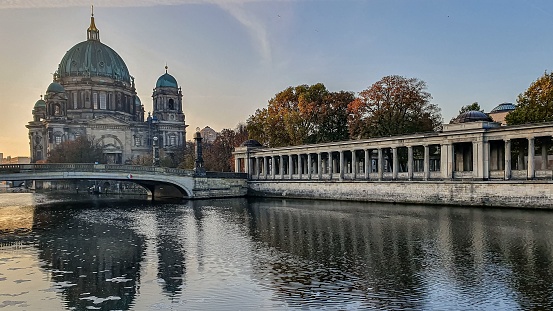 Spectacular shot of Berlin Cathedral and Alte Nationalgalerie reflecting in a river at a sunset